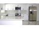 Well-lit kitchen featuring white cabinets, stainless steel appliances, and sleek marble countertops at 1109 N Obrien St, Tampa, FL 33607