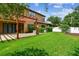 Large backyard with a covered patio, well-kept lawn, and privacy fence at 11407 Drifting Leaf Dr, Riverview, FL 33579