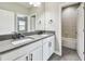 Double sink bathroom vanity with dark hardware and access to the shower and tub at 11407 Drifting Leaf Dr, Riverview, FL 33579