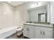 Bright bathroom features a shower-tub combination and vanity with a granite countertop at 11407 Drifting Leaf Dr, Riverview, FL 33579
