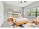 Cozy bedroom with natural light, ceiling fan, rocking chair and colorful rug at 11407 Drifting Leaf Dr, Riverview, FL 33579