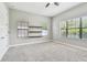 Bright bedroom with three windows, neutral walls, and carpeted flooring at 11407 Drifting Leaf Dr, Riverview, FL 33579