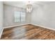 Empty bedroom with hardwood floors, neutral walls, and decorative chandelier at 11407 Drifting Leaf Dr, Riverview, FL 33579