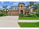 Stunning two-story home featuring a three-car garage and lush landscaping in a tropical setting at 11407 Drifting Leaf Dr, Riverview, FL 33579