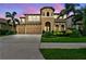 Stunning two-story home featuring a three-car garage and lush landscaping in a tropical setting at 11407 Drifting Leaf Dr, Riverview, FL 33579