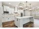 Bright kitchen features white cabinets, stainless appliances, tiled backsplash, large island and modern light fixtures at 11407 Drifting Leaf Dr, Riverview, FL 33579