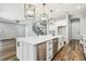 Kitchen island with stainless dishwasher, farm sink, plenty of storage and modern pendant lighting at 11407 Drifting Leaf Dr, Riverview, FL 33579