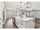 Large kitchen island with stainless dishwasher, farmhouse sink, bar seating and stylish pendant lighting at 11407 Drifting Leaf Dr, Riverview, FL 33579