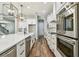 Modern kitchen with stainless steel appliances, white cabinets, a subway tile backsplash and wood flooring at 11407 Drifting Leaf Dr, Riverview, FL 33579