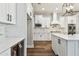 Gourmet kitchen with stainless appliances, beverage fridge, white cabinetry, hardwood floors and stone countertops at 11407 Drifting Leaf Dr, Riverview, FL 33579