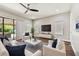 Bright living room with white furniture, hardwood floors, and a large TV at 11407 Drifting Leaf Dr, Riverview, FL 33579