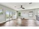 Spacious living area with wood flooring, a ceiling fan, a balcony, and windows providing lots of light at 11407 Drifting Leaf Dr, Riverview, FL 33579