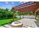 A shaded outdoor patio with a beautiful wood pergola and well-maintained lawn at 11407 Drifting Leaf Dr, Riverview, FL 33579