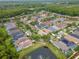 Aerial view of a community with houses situated around a pond with a fountain and screened pools at 11623 Greensleeve Ave, Tampa, FL 33626