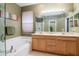 Bright bathroom featuring a double vanity, soaking tub, and a large mirror at 11623 Greensleeve Ave, Tampa, FL 33626