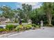 Community entrance with stone pillars, wrought iron gate, manicured shrubs and colorful flower beds at 11623 Greensleeve Ave, Tampa, FL 33626