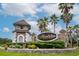 Stone community entrance to Mandolin Reserve with lush landscaping and palm trees under a partly cloudy sky at 11623 Greensleeve Ave, Tampa, FL 33626