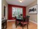 Inviting dining room with a round table, red accent wall, and large window providing natural light at 11623 Greensleeve Ave, Tampa, FL 33626