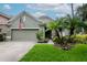 Charming single-story home with a lush green lawn, mature landscaping, and an attached two-car garage at 11623 Greensleeve Ave, Tampa, FL 33626