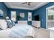 Comfortable main bedroom with a tray ceiling, blue walls, white dressers, and plantation shutters at 11623 Greensleeve Ave, Tampa, FL 33626