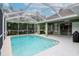 Enclosed pool area with a covered patio and serene backyard views at 11623 Greensleeve Ave, Tampa, FL 33626