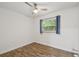 Inviting bedroom features wood-look flooring, a ceiling fan, and a window with blue curtains at 1311 W Perdiz St, Tampa, FL 33612