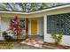 Welcoming home entrance featuring a vibrant yellow door and mid-century modern design accents at 1311 W Perdiz St, Tampa, FL 33612