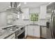 Well-lit kitchen featuring stainless steel appliances, granite countertops, and modern fixtures at 1311 W Perdiz St, Tampa, FL 33612