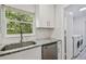 Modern kitchen with granite countertops, stainless steel appliances, and convenient access to laundry area at 1311 W Perdiz St, Tampa, FL 33612
