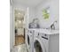 Bright laundry room with modern washer and dryer adjacent to the kitchen at 1311 W Perdiz St, Tampa, FL 33612