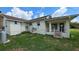 Rear view of home featuring neutral siding, a porch, and a large grassy yard at 13330 Fort King Rd, Dade City, FL 33525