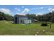 Exterior view of a barn with metal siding and a red roof, set on a large, grassy lot at 13330 Fort King Rd, Dade City, FL 33525