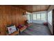Cozy sunroom featuring wood-paneled walls, seating, and natural light at 13330 Fort King Rd, Dade City, FL 33525