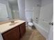 Bathroom with wood cabinet vanity and tub-shower combination featuring modern fixtures and lighting at 13551 Banner Rd, Spring Hill, FL 34609