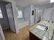Bathroom with double sinks, granite counters, soaking tub, and walk-in shower in separate room at 13551 Banner Rd, Spring Hill, FL 34609