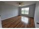 Bedroom with wood floors, bright natural light from large window at 13551 Banner Rd, Spring Hill, FL 34609