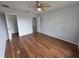 Neutral bedroom with wood floors, a ceiling fan, and access to another room/closet at 13551 Banner Rd, Spring Hill, FL 34609