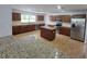 Modern kitchen with stainless steel appliances, central island, and spacious granite countertops at 13551 Banner Rd, Spring Hill, FL 34609