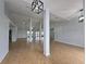 Bright, open-concept living space with wood-look tile flooring and modern light fixtures at 13551 Banner Rd, Spring Hill, FL 34609