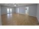 Spacious living room with wood tile floors, ceiling fan, and double doors to the backyard at 13551 Banner Rd, Spring Hill, FL 34609