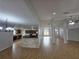 Spacious living room with wood-look tile flooring open to the kitchen with a breakfast bar at 13551 Banner Rd, Spring Hill, FL 34609