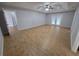 Large living room featuring wood-look tile flooring, ceiling fan, and access to the back patio at 13551 Banner Rd, Spring Hill, FL 34609