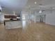 Spacious open-concept living area with tile flooring, leading to a modern kitchen with updated appliances at 13551 Banner Rd, Spring Hill, FL 34609