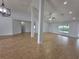 Spacious living room with wood-look tile flooring, high ceilings, and natural lighting at 13551 Banner Rd, Spring Hill, FL 34609