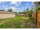 Large backyard featuring a partial fence and mature palm trees. Perfect for outdoor activities and enjoying the Florida lifestyle at 1410 Moss Laden Ct, Brandon, FL 33511