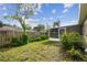 The backyard is lush and green, complemented by a screened-in porch, a wooden fence, and a canopy of mature trees at 1410 Moss Laden Ct, Brandon, FL 33511