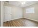 Bright bedroom with wood-look flooring, a ceiling fan, and a window for natural light at 1410 Moss Laden Ct, Brandon, FL 33511