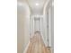 Well-lit hallway with fresh paint, wood-look flooring, and several doorways at 1410 Moss Laden Ct, Brandon, FL 33511