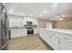 Updated kitchen with white cabinets, stainless steel appliances, island and wood-look floors at 1410 Moss Laden Ct, Brandon, FL 33511