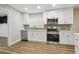 Well-lit kitchen with stainless steel appliances, white cabinets, and modern fixtures at 1410 Moss Laden Ct, Brandon, FL 33511